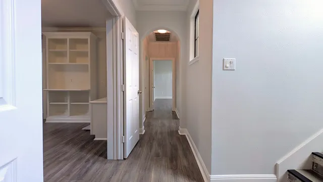a view of a hallway with wooden floor and closet