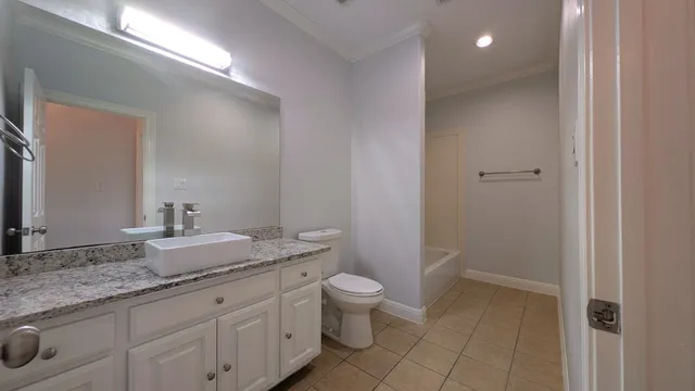a bathroom with a granite countertop sink a toilet and a mirror