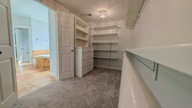 a view of walk in closet with empty racks