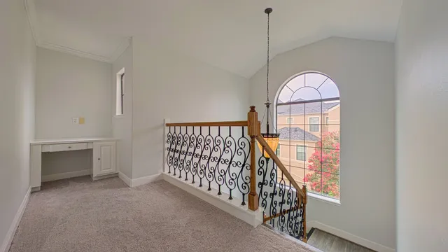 a view of a hallway with wooden floor and a bathroom