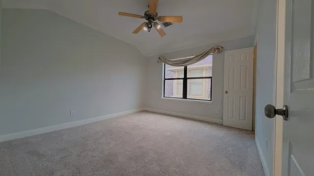 a view of an empty room and chandelier fan