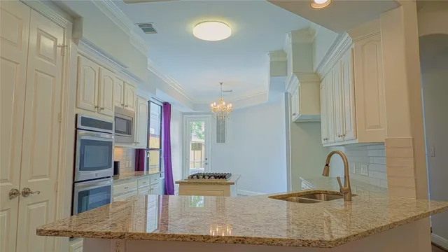 a kitchen with kitchen island a sink appliances and cabinets
