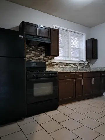 a kitchen with granite countertop a stove and a sink