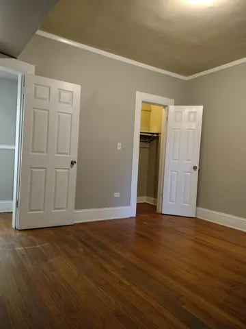 an empty room with wooden floor and closet