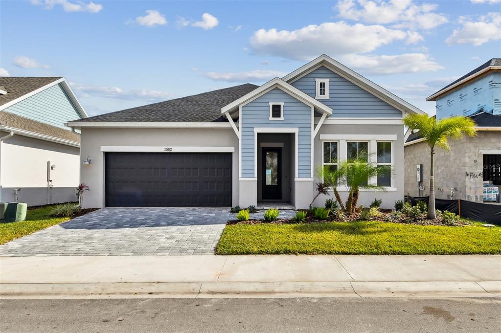 1582 Running Tide Place Sarasota, FL 34240 - Photo 1 of 1 a front view of a house with a yard and garage