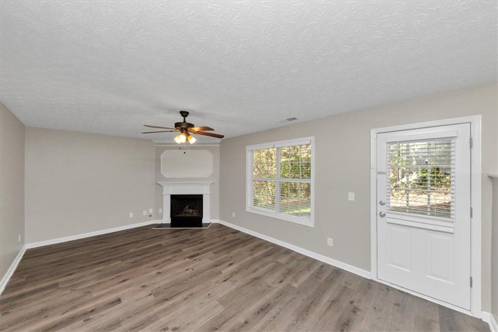 4169 Riverbank Court Decatur, GA 30034 - Photo 11 of 32 an empty room with windows fireplace and wooden floor