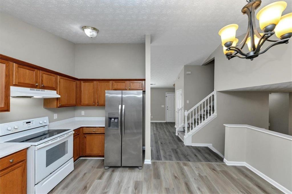 4169 Riverbank Court Decatur, GA 30034 - Photo 8 of 32 a kitchen with stainless steel appliances granite countertop a refrigerator a sink dishwasher a stove and a dining table with wooden floor