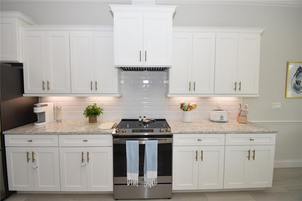 114 Del Palma Drive Palm Coast, FL 32137 - Photo 12 of 63 a kitchen with white cabinets and white appliances