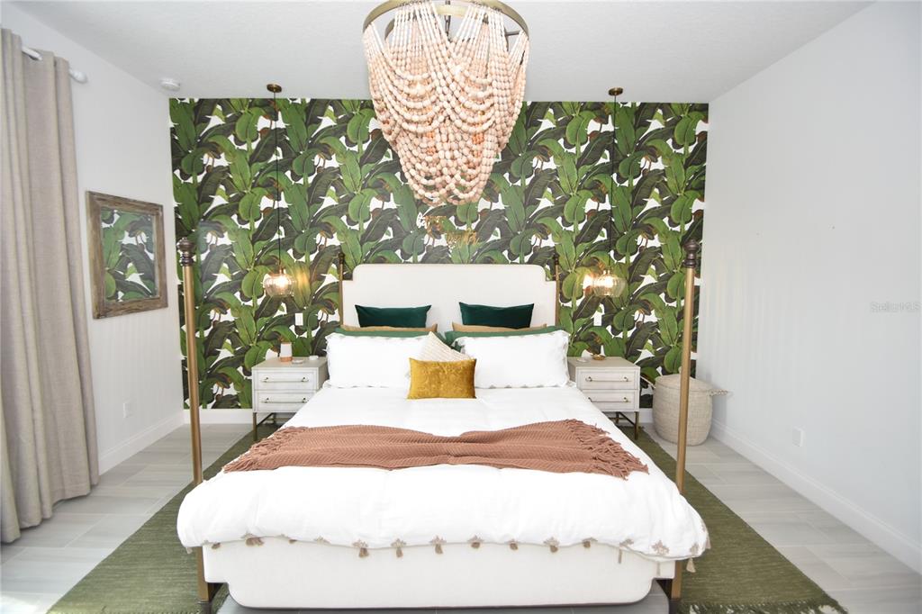 114 Del Palma Drive Palm Coast, FL 32137 - Photo 28 of 63 a bedroom with a bed and a chandelier