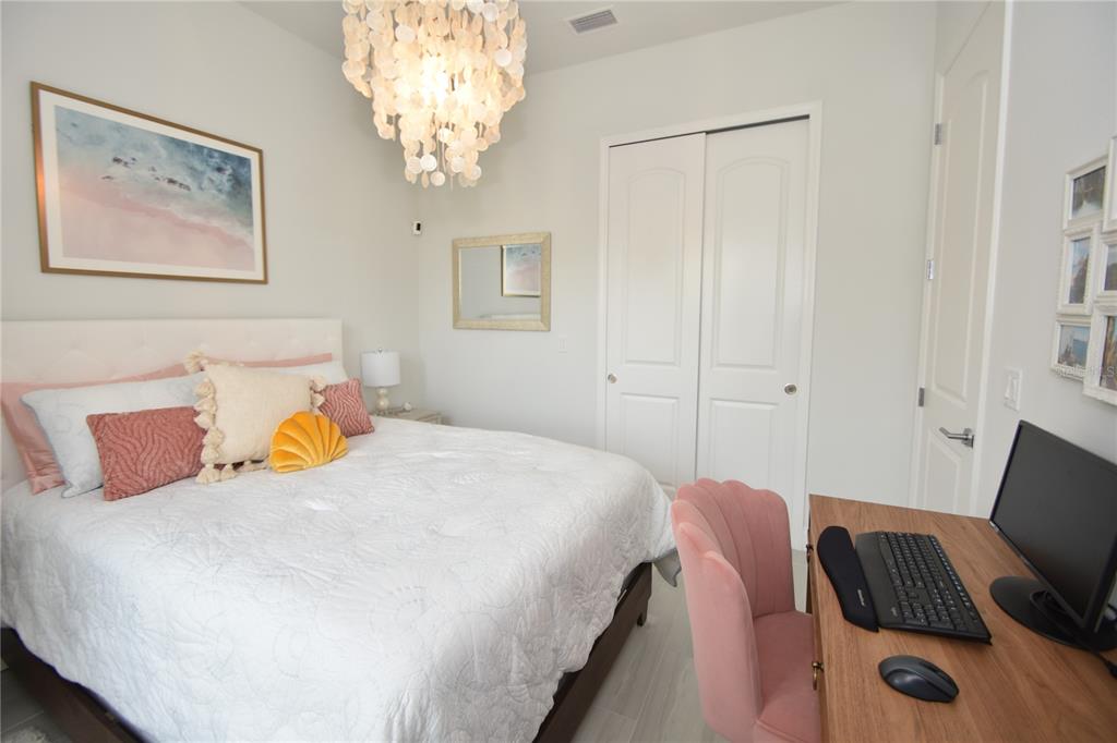 114 Del Palma Drive Palm Coast, FL 32137 - Photo 40 of 63 a bedroom with a bed and a chandelier