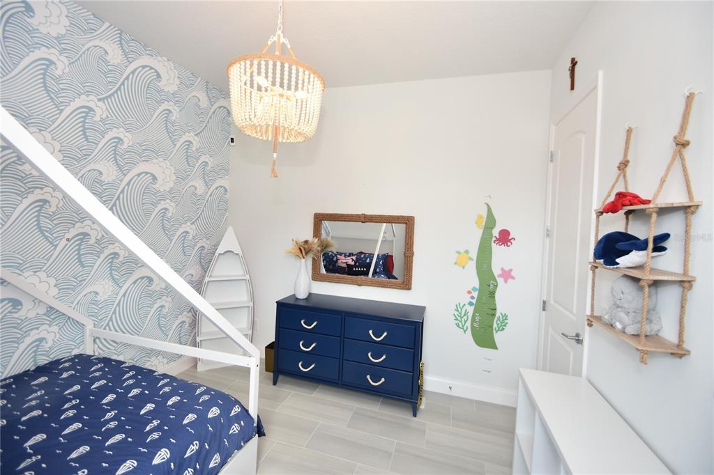 114 Del Palma Drive Palm Coast, FL 32137 - Photo 44 of 63 a bedroom with a bed and a chandelier