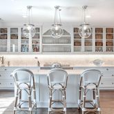 a table with a chandelier and kitchen view