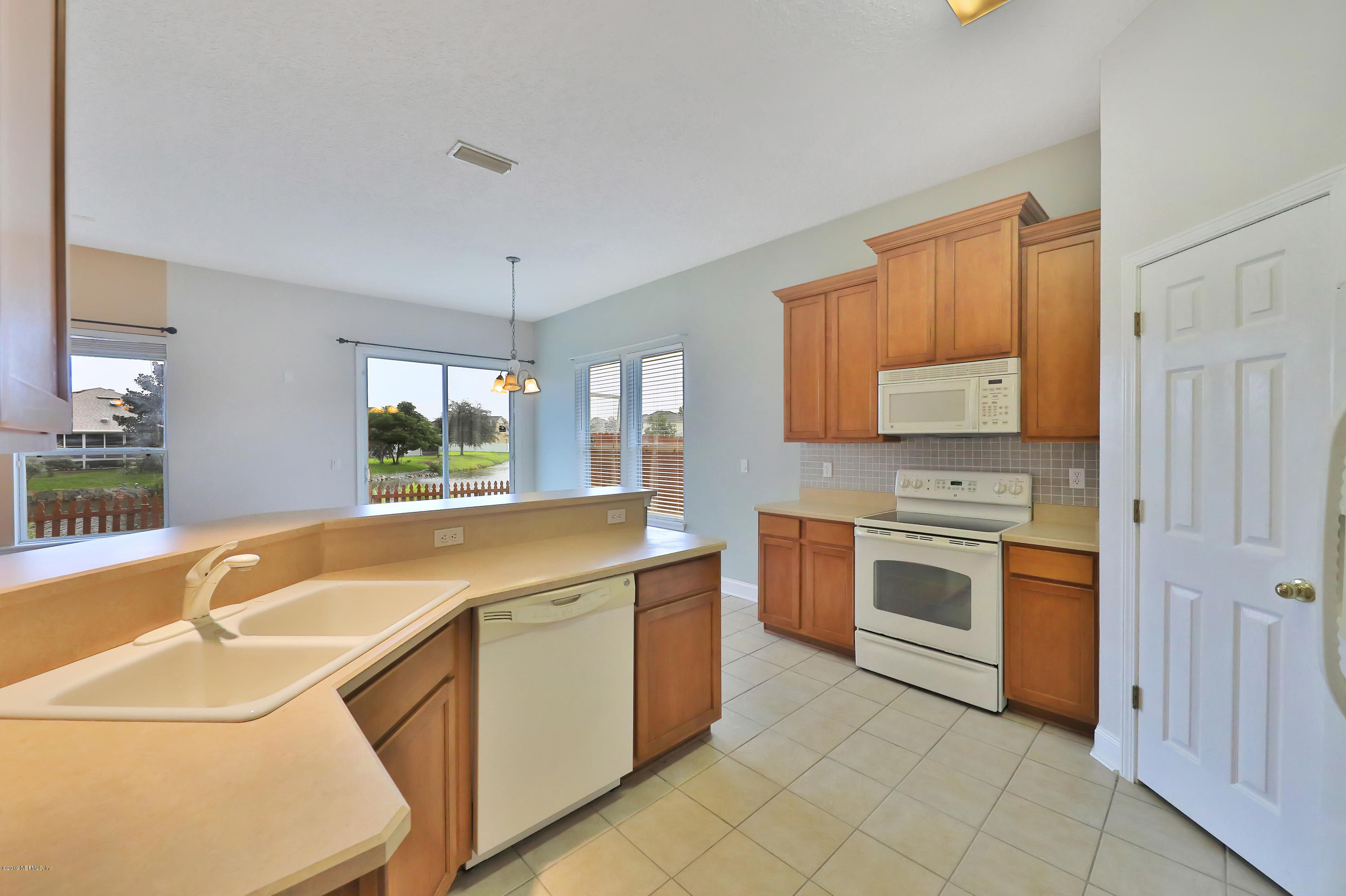 9189 Raptor Drive Jacksonville, FL 32221 - Photo 8 of 23 a kitchen with granite countertop a sink stove and cabinets