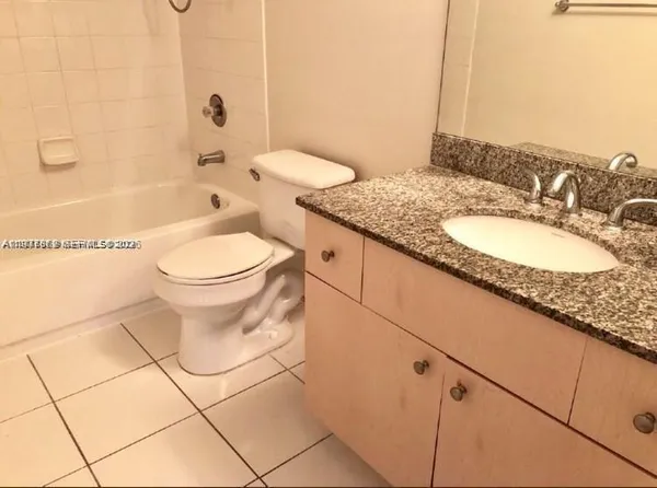 a bathroom with a granite countertop sink a toilet and bathtub