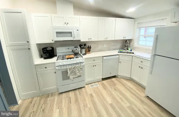 a kitchen with a sink a stove a refrigerator and cabinets