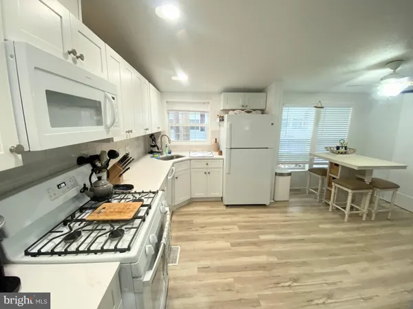 a kitchen with a refrigerator and a stove top oven