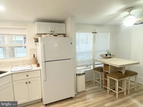 a white kitchen with a refrigerator a sink and white cabinets