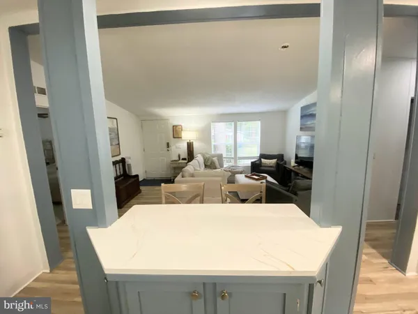 a living room with furniture a large window and a wooden floor