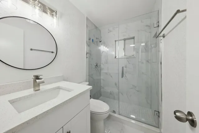 a bathroom with a sink toilet and shower