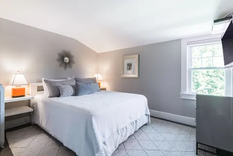 a bedroom with a bed and a window