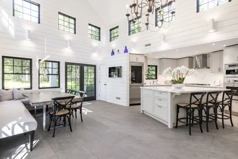 a kitchen with a white table chairs and a refrigerator