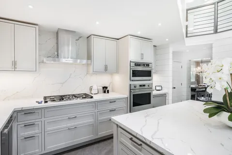 a kitchen with cabinets stainless steel appliances and wooden floor