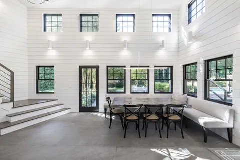 a living room with furniture and large windows