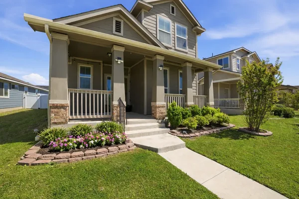 a front view of a house with a yard and fence