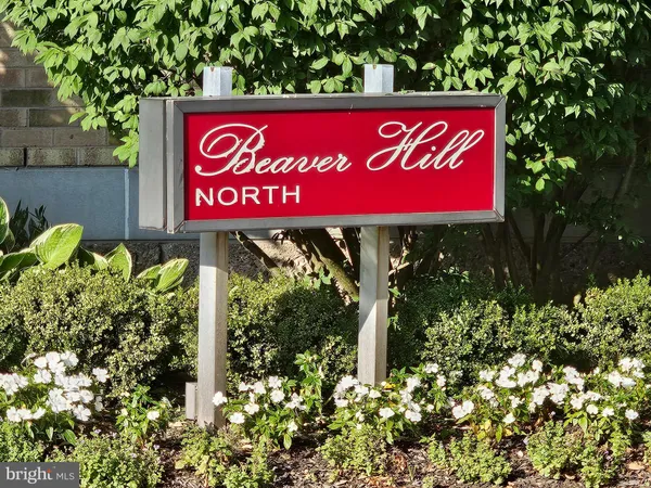 a sign that is sitting in front of flowers