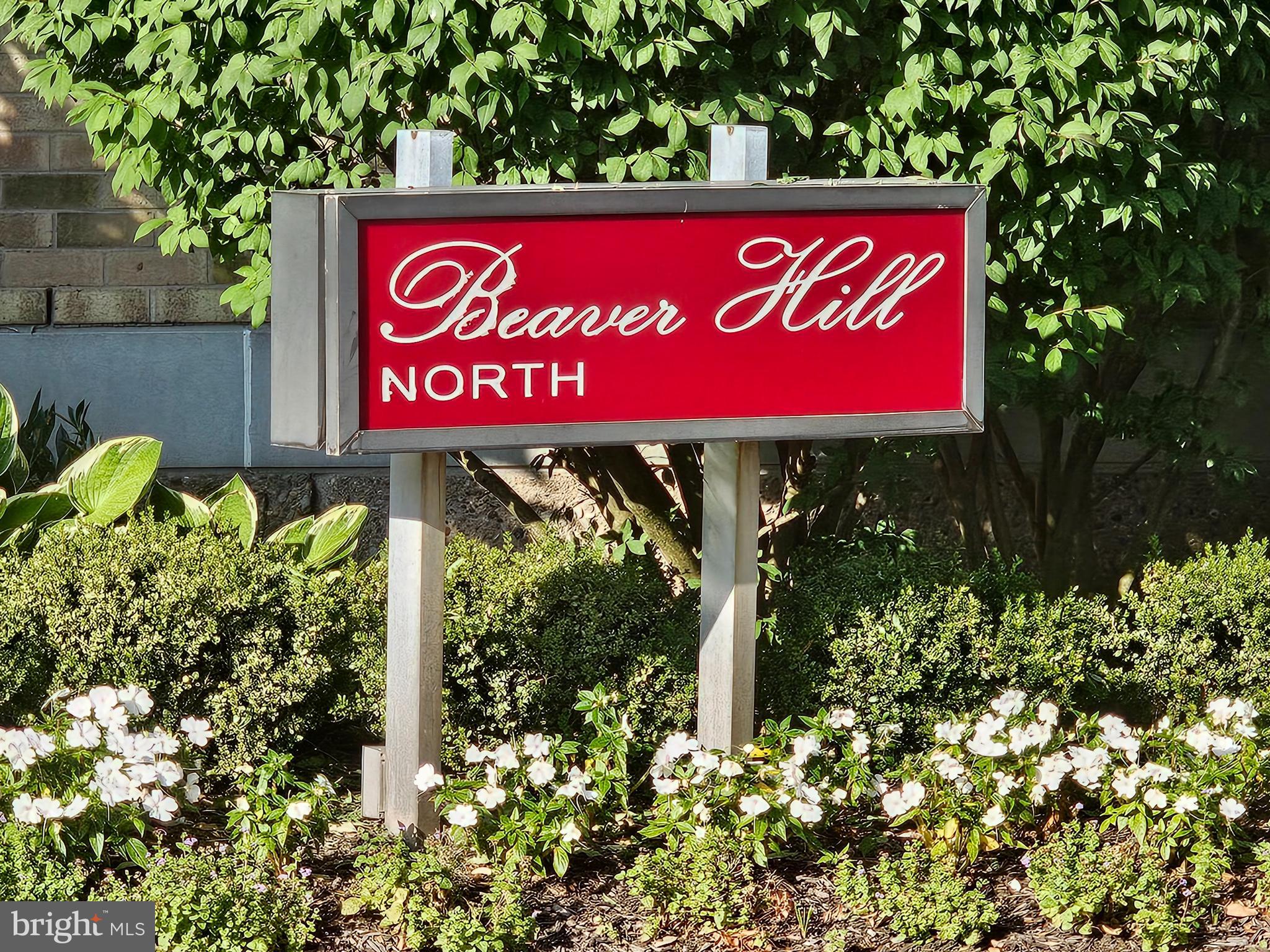 a sign that is sitting in front of flowers