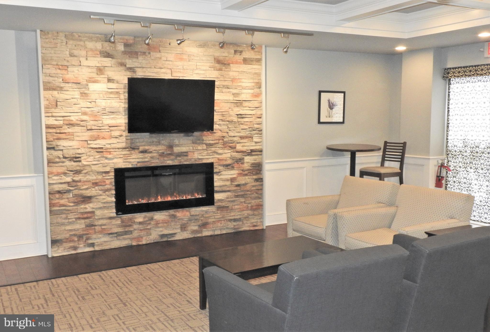 309 Florence Avenue, Unit 627N Jenkintown, PA 19046 - Photo 21 of 35 a living room with a fireplace and a flat screen tv