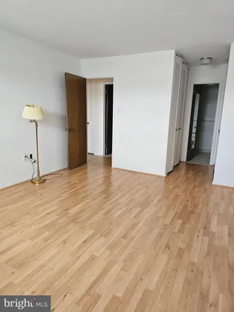 a view of an empty room with closet and a window