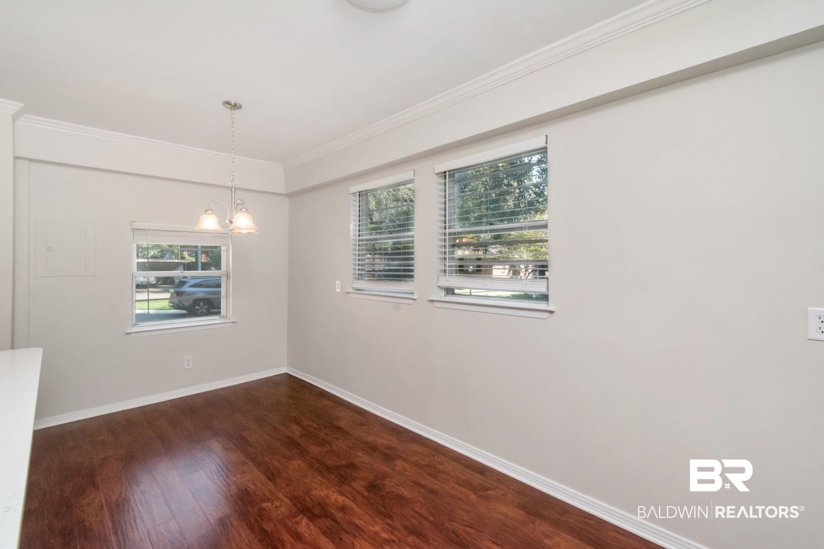 2105 Upham Court Mobile, AL 36607 - Photo 15 of 32 Unfurnished room featuring dark wood-style flooring, ornamental molding, and a chandelier