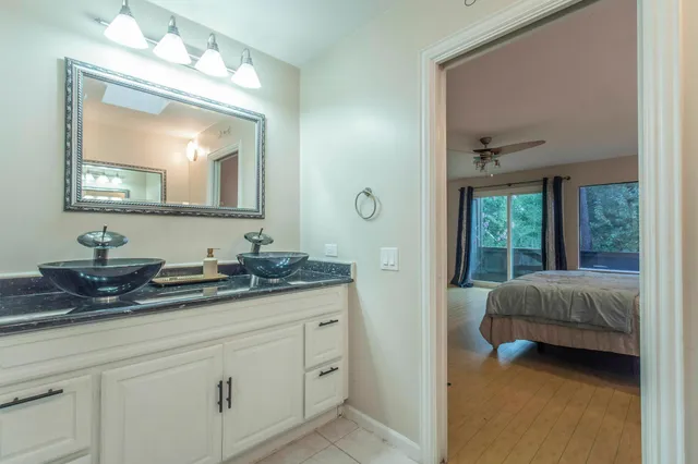 a bedroom with a large bed a chandelier and dresser