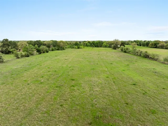 a view of a field with an trees in the background