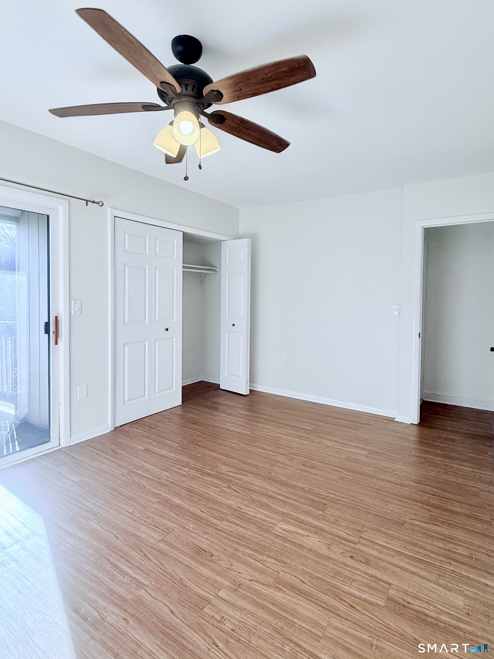 175 Mill Pond Road, Unit 106 Hamden, CT 06514 - Photo 11 of 22 a view of an empty room with wooden floor