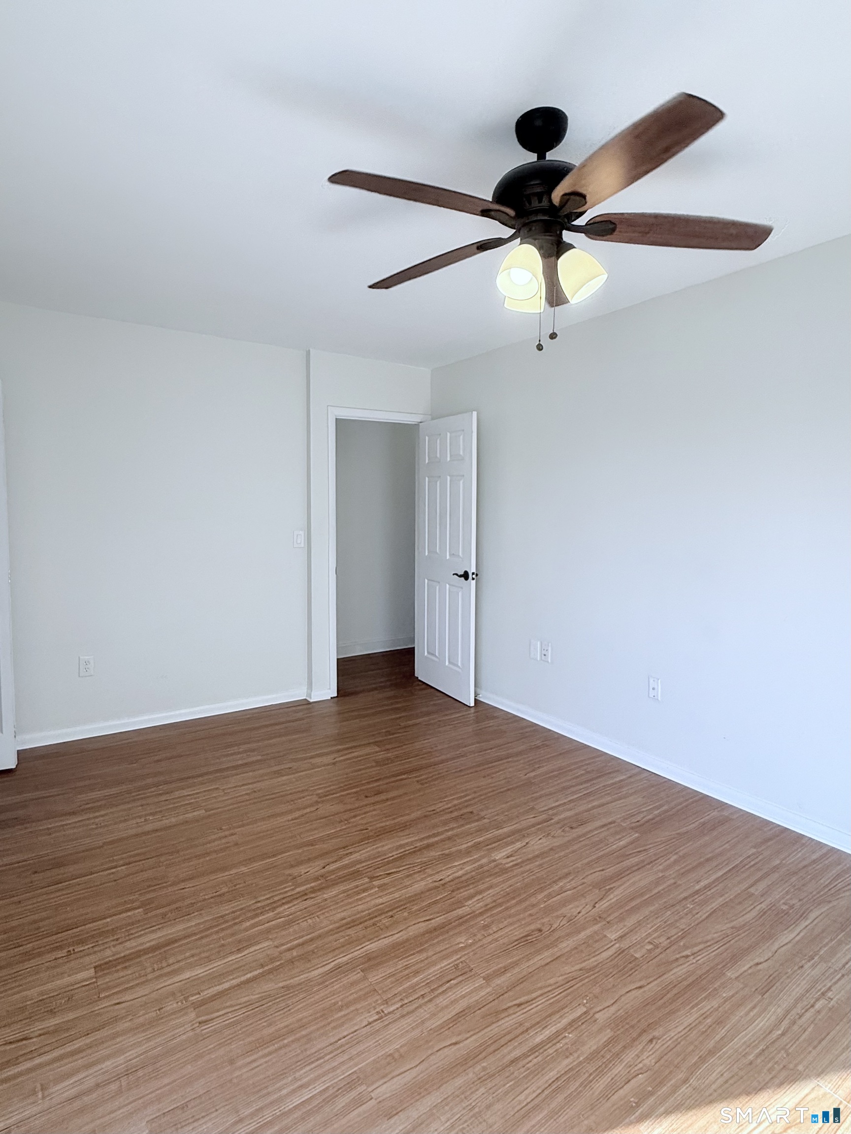 175 Mill Pond Road, Unit 106 Hamden, CT 06514 - Photo 12 of 22 a view of an empty room with wooden floor