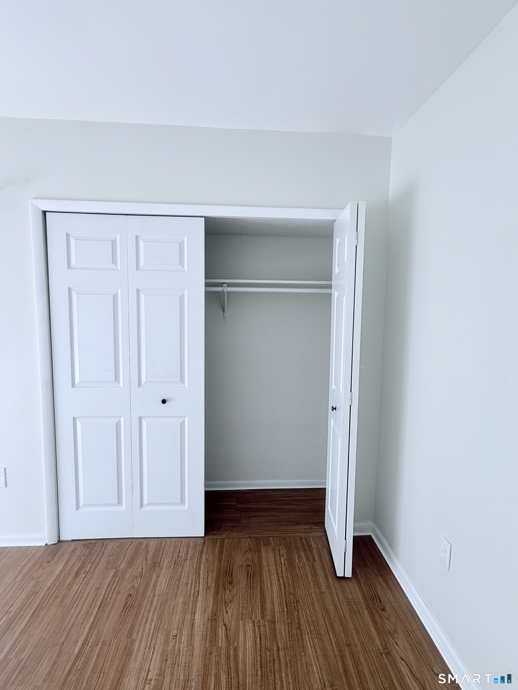 175 Mill Pond Road, Unit 106 Hamden, CT 06514 - Photo 14 of 22 a view of an empty room with wooden floor