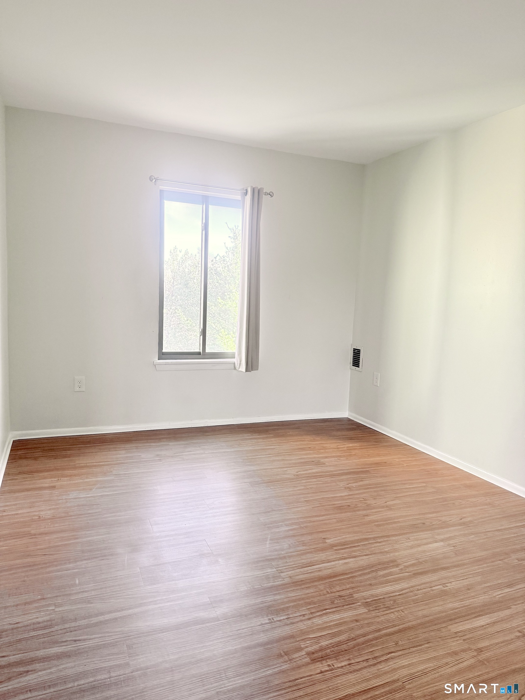 175 Mill Pond Road, Unit 106 Hamden, CT 06514 - Photo 15 of 22 a view of an empty room with wooden floor and a window