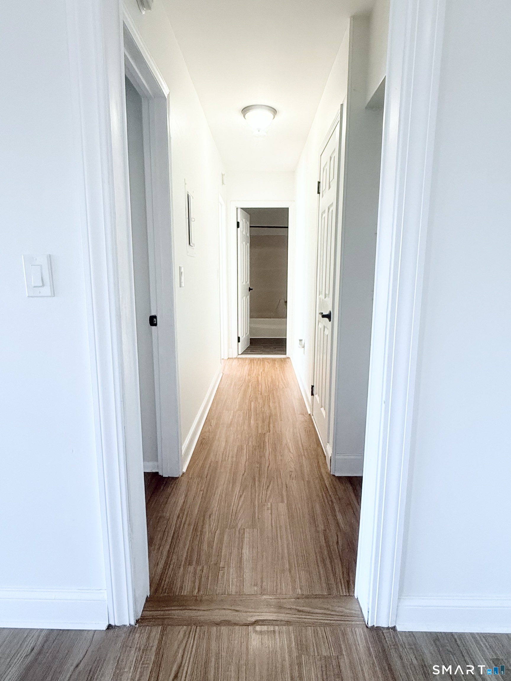 175 Mill Pond Road, Unit 106 Hamden, CT 06514 - Photo 16 of 22 a view of a hallway with wooden floor