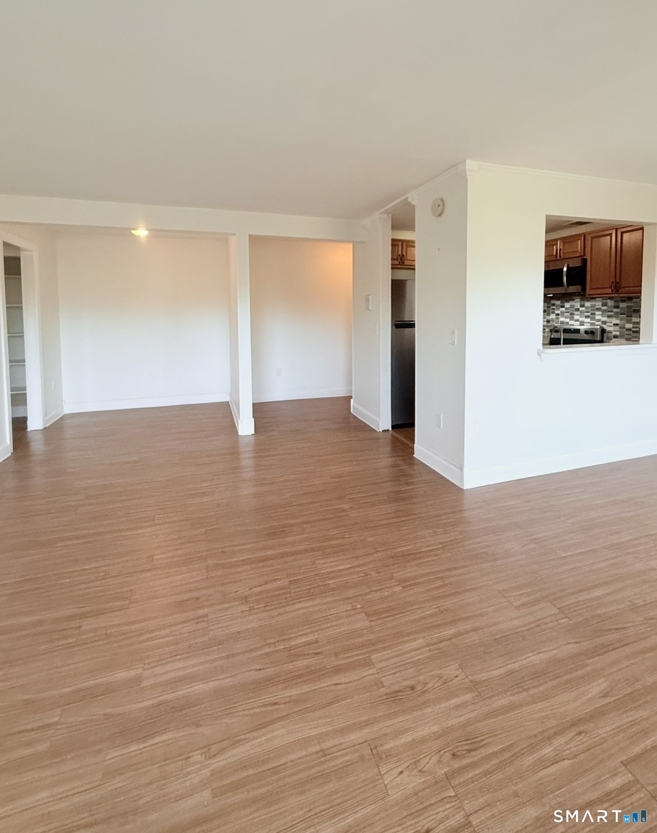 175 Mill Pond Road, Unit 106 Hamden, CT 06514 - Photo 3 of 22 a view of an empty room with wooden floor