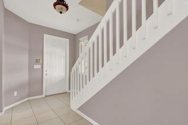 a view of staircase with railing and white walls