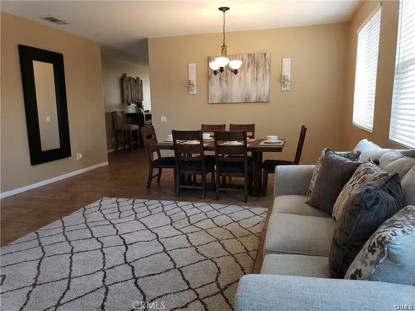 a living room with furniture a dining table and a window