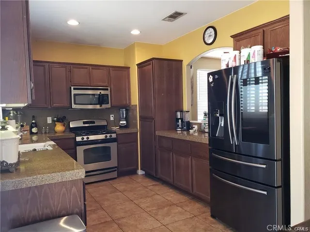 a kitchen with granite countertop a refrigerator stove and microwave