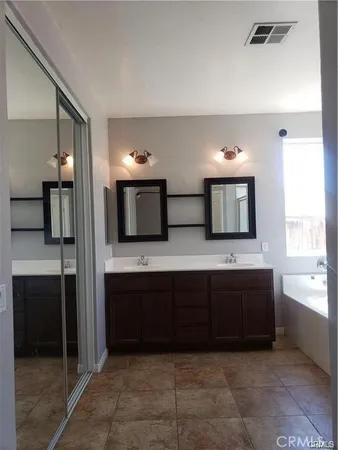 a spacious bathroom with a bathtub and a double vanity sink