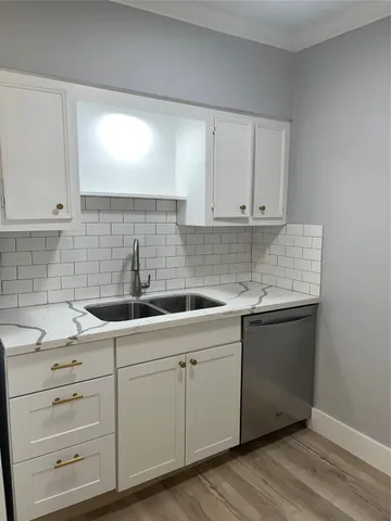 a kitchen with white cabinets and sink