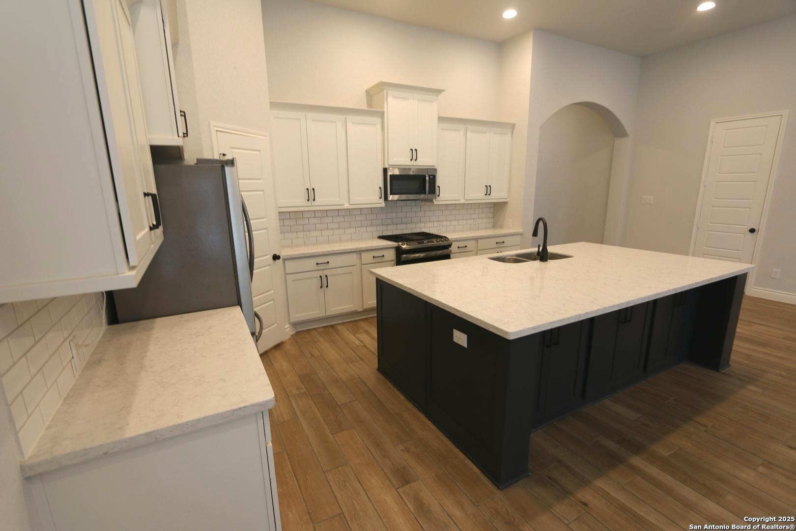 2965 Grove Way Seguin, TX 78155 - Photo 15 of 60 a kitchen with a sink a stove a refrigerator and a refrigerator