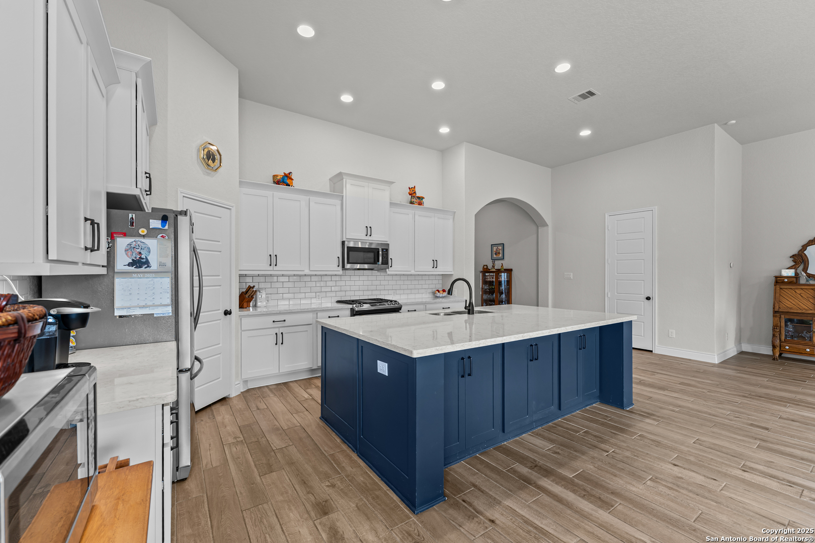 2965 Grove Way Seguin, TX 78155 - Photo 39 of 60 a kitchen with kitchen island a sink stove and wooden floor