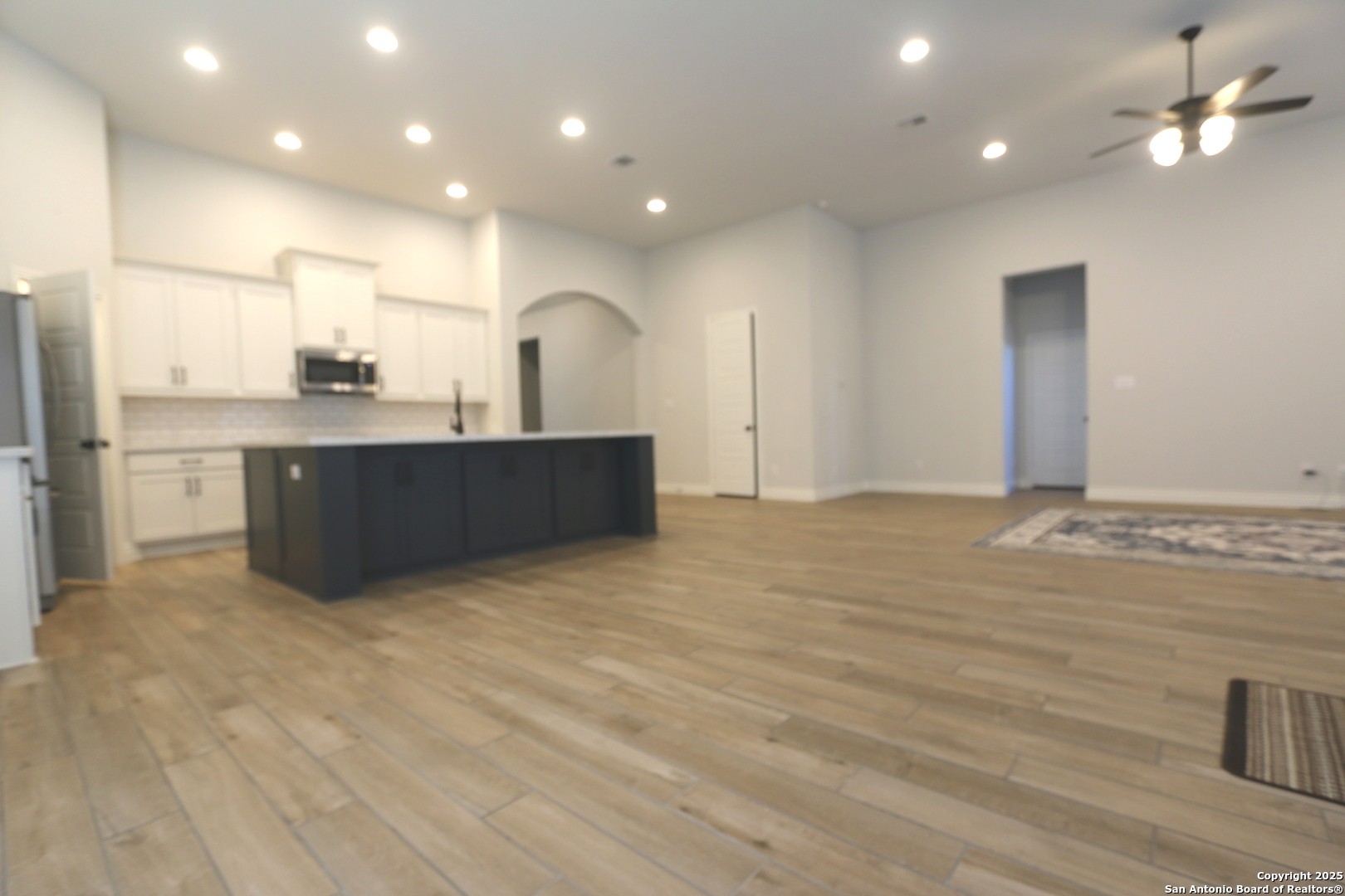 2965 Grove Way Seguin, TX 78155 - Photo 5 of 60 a view of kitchen and empty room with wooden floor and windows