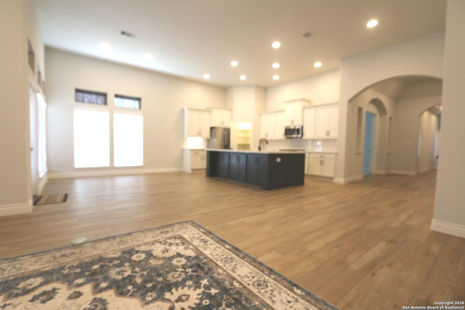 2965 Grove Way Seguin, TX 78155 - Photo 8 of 60 a view of a living room with kitchen island stainless steel appliances wooden floor and a window